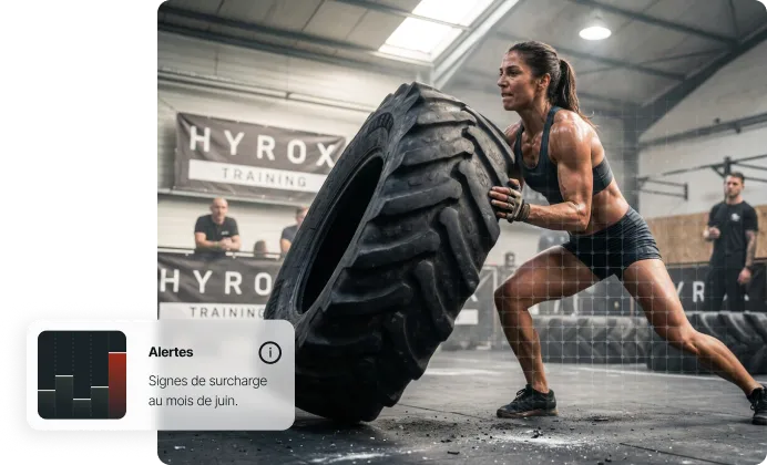 Femme musclée soulève un pneu géant dans une salle d'entraînement Hyrox.