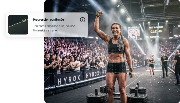 Athlète femme levant le poing en signe de victoire devant une foule lors d’une compétition HYROX.