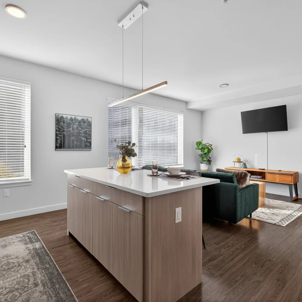 Kitchen with light wood cabinets overview in to the living room