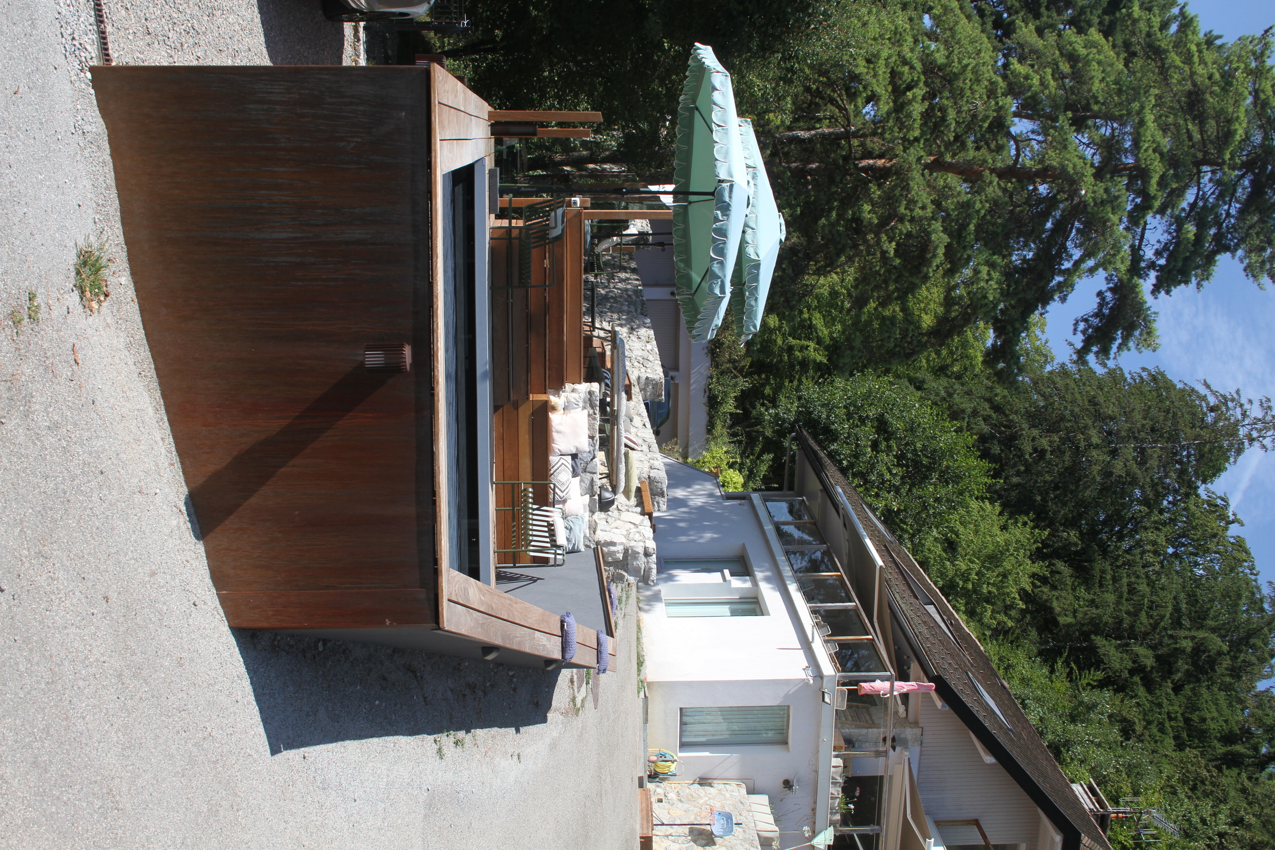 Salon de jardin et terrasse en bois offrant une vue sur le lac et la montagne.