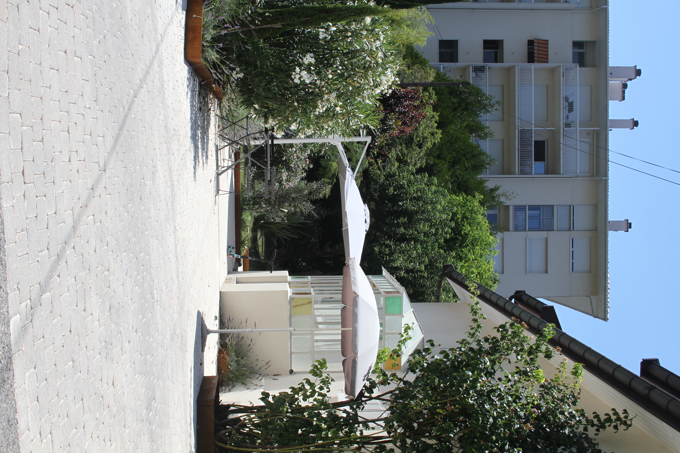 Vue rapprochée sur le bassin de la piscine et l'espace détente avec parasol.