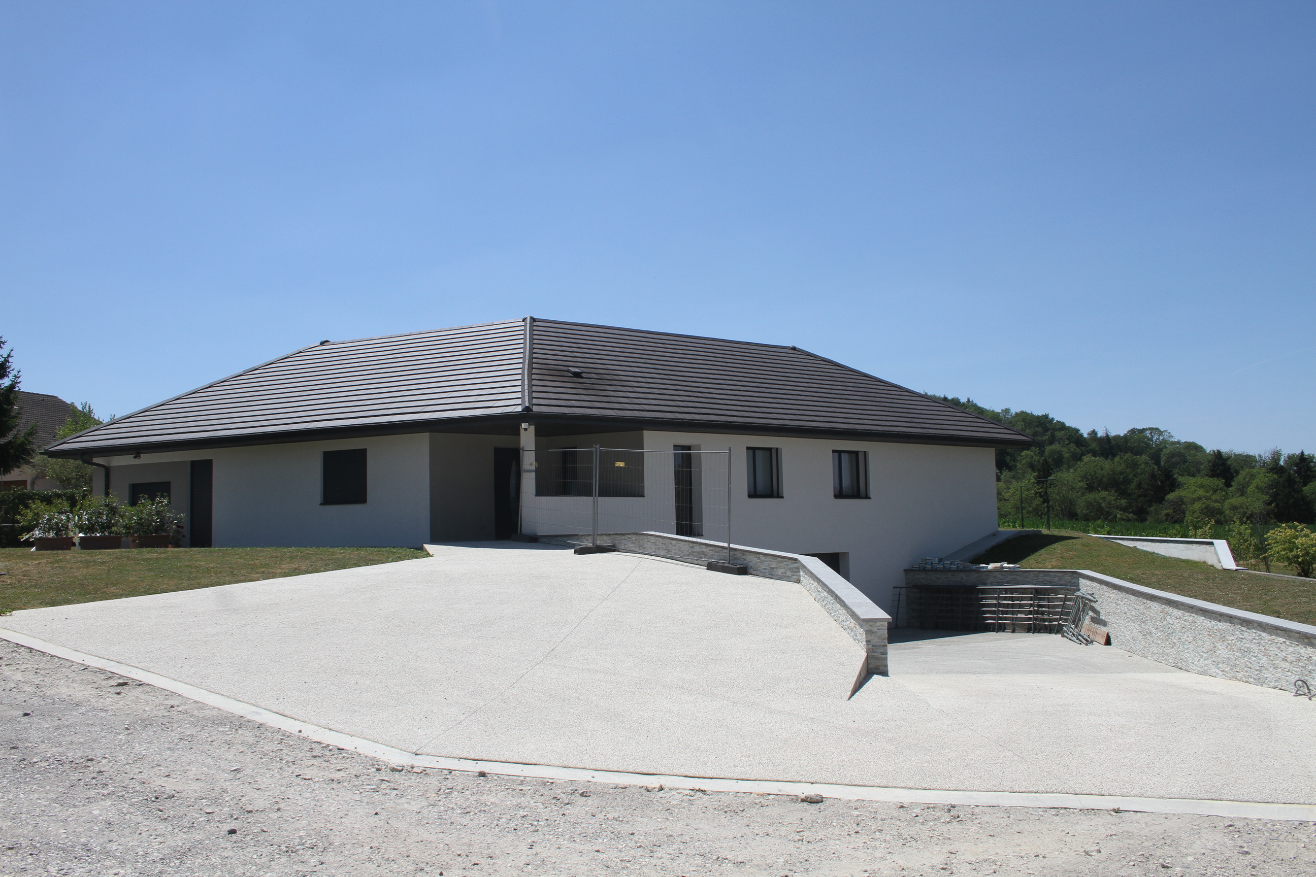 Vue d'ensemble d'une maison moderne avec une rampe d'accès carrossable vers le garage.