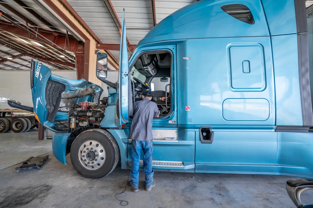 Mechanic working on a blue semi-truck