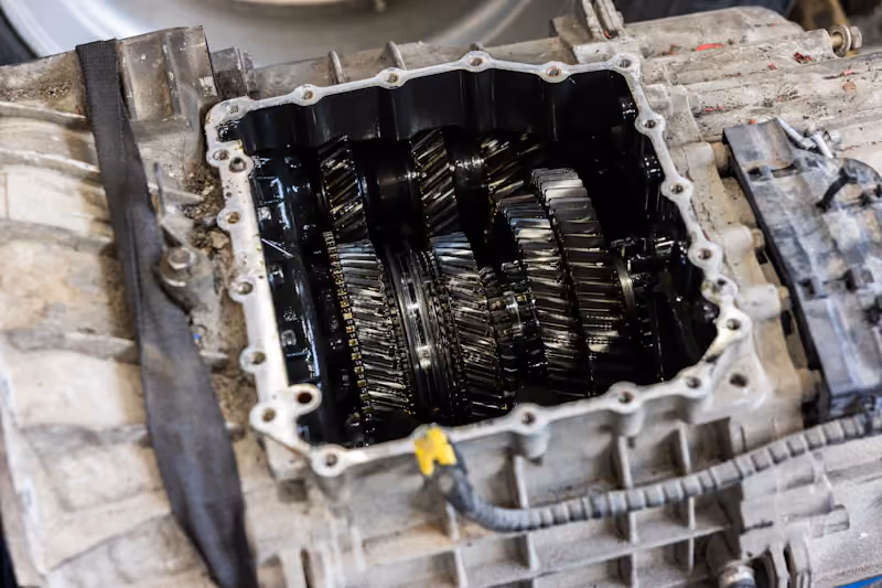 Heavy-duty repair with an open commercial truck transmission exposing internal gears during transmission service.