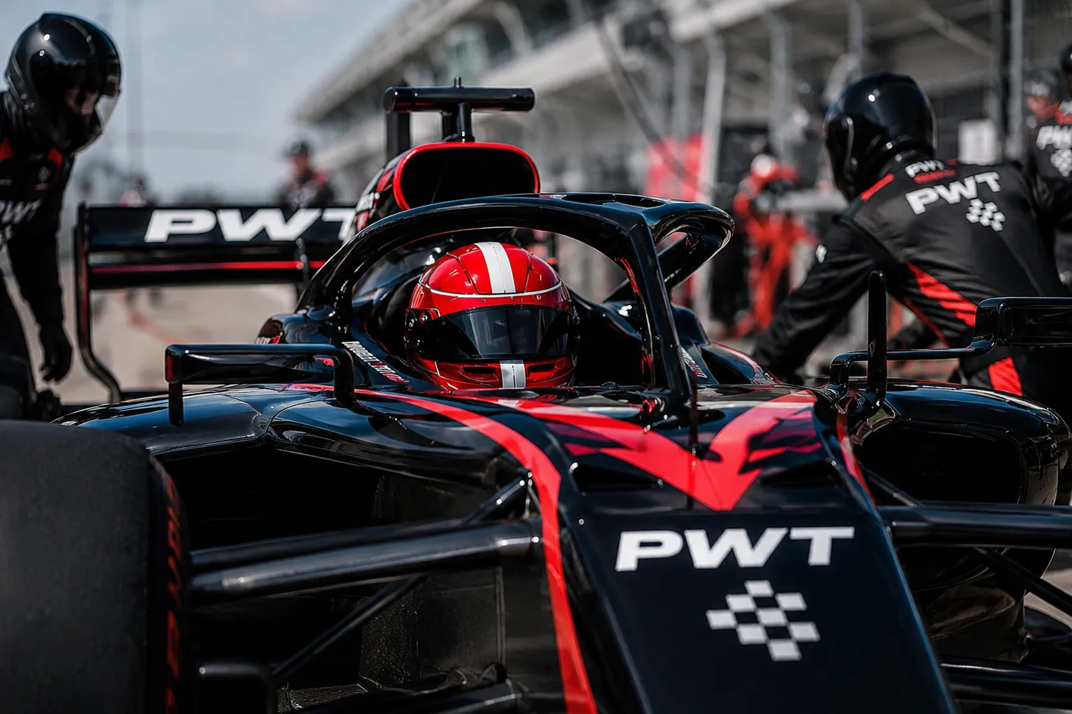 A PWT driver waits in the cockpit on the grid while the crew makes final checks.