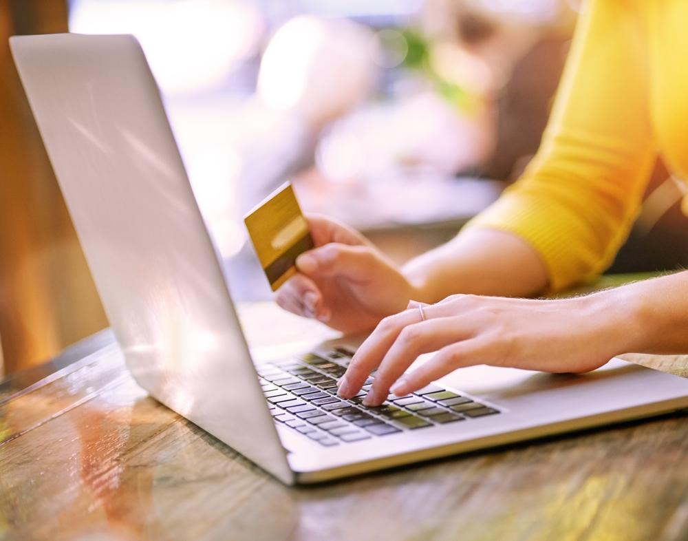A customer makes an online payment using a credit card and laptop.
