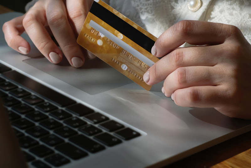 A customer makes a purchase using a credit card and laptop computer.