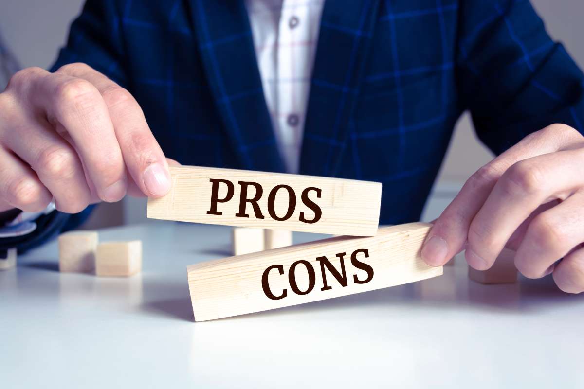 Man holding blocks where one says Pros the other says Cons