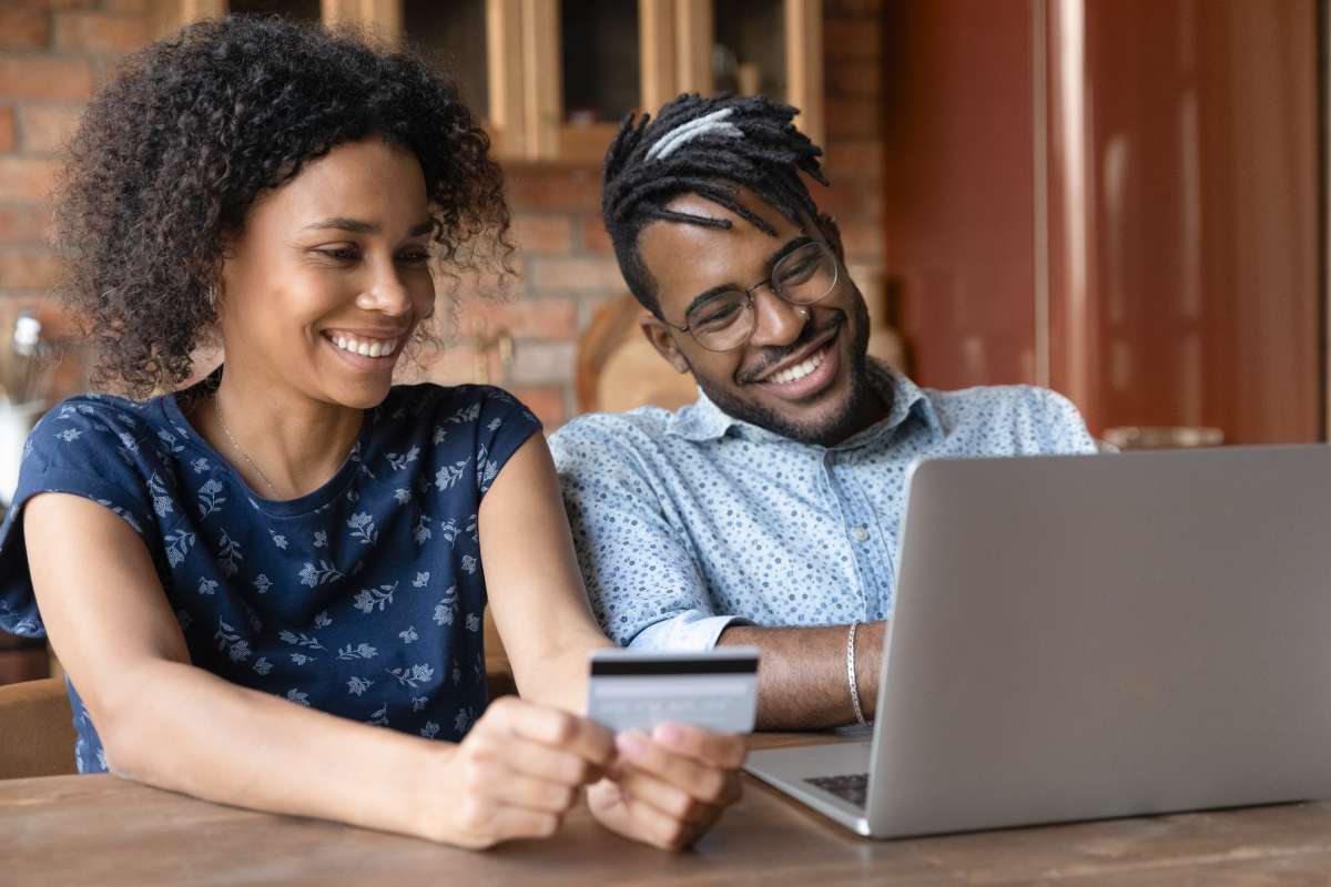 A couple makes a purchase online using a laptop computer.