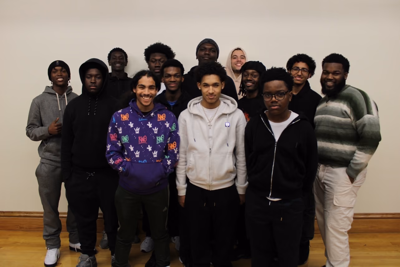 Group of approximately fourteen students posing together indoors