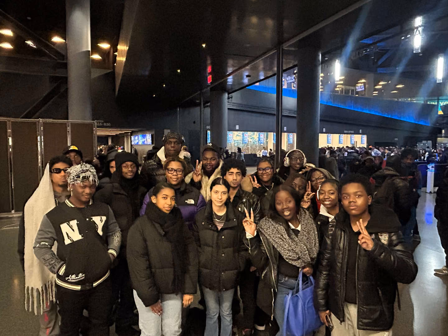 Students posing together inside a large arena on a field trip