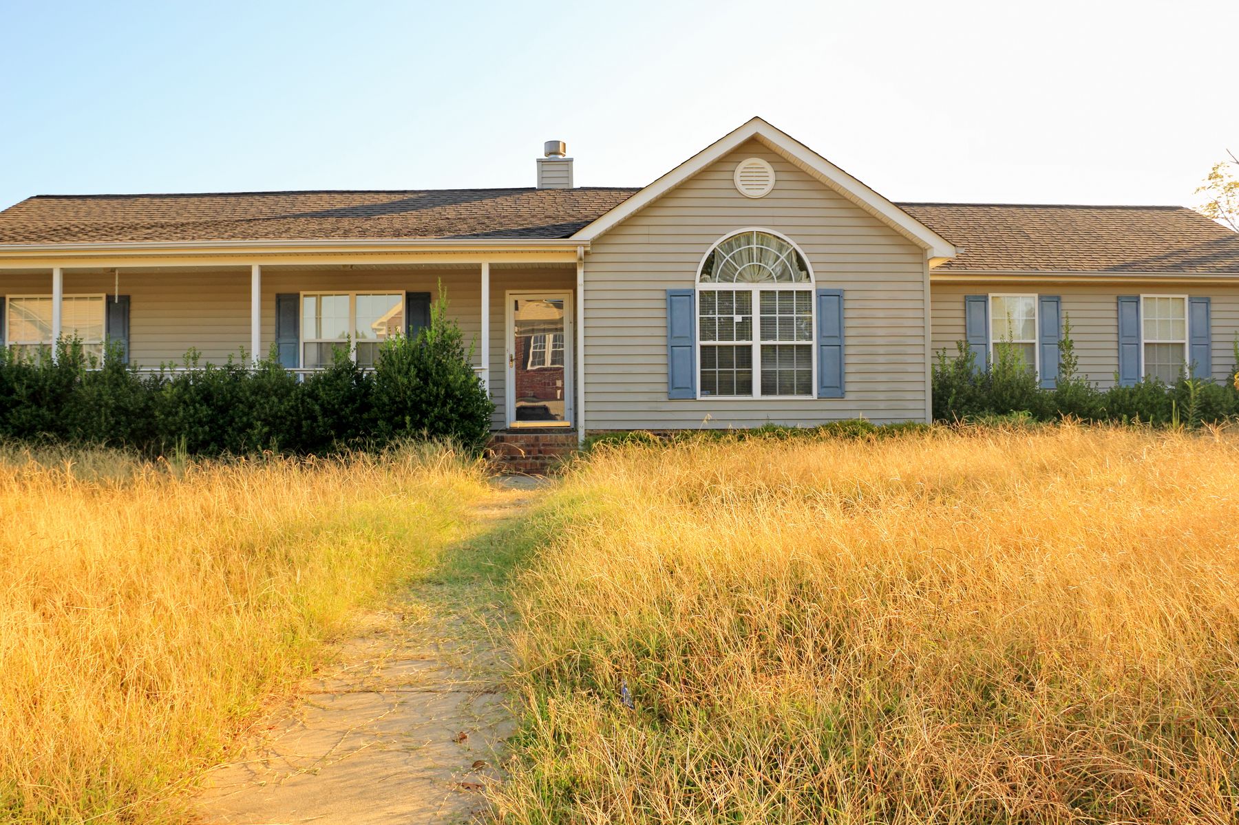 Vacant single-family house with overgrown front yard