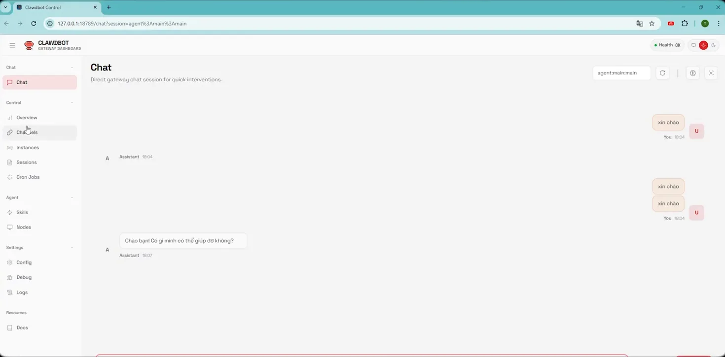 Bảng điều khiển CLAWDBOT GATEWAY DASHBOARD mở ở địa chỉ 127.0.0.1:18789, thanh bên trái có các mục Chat, Overview, Channels, Instances, Sessions, Cron Jobs, Skills, Nodes, Config, Debug, Logs và Docs, khung chat bên phải hiện vài tin nhắn xin chào