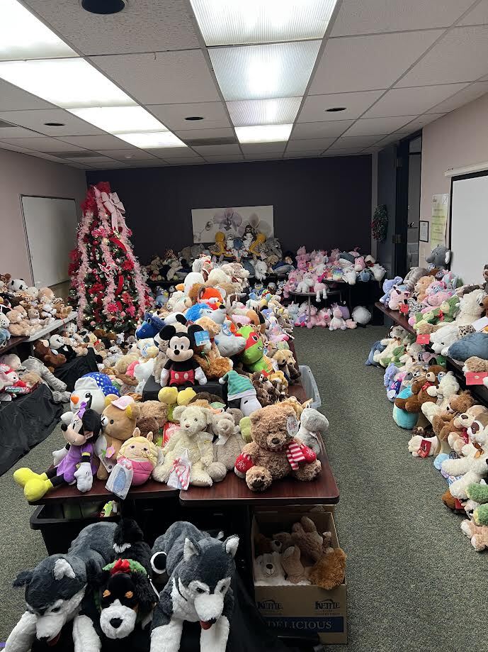 Tables piled with donated stuffed animals for Winter Open House