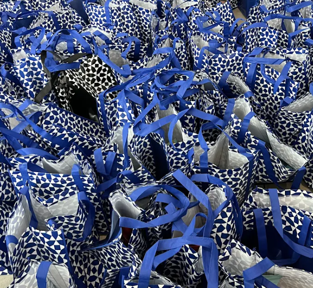 Rows of filled blue gift bags ready for families