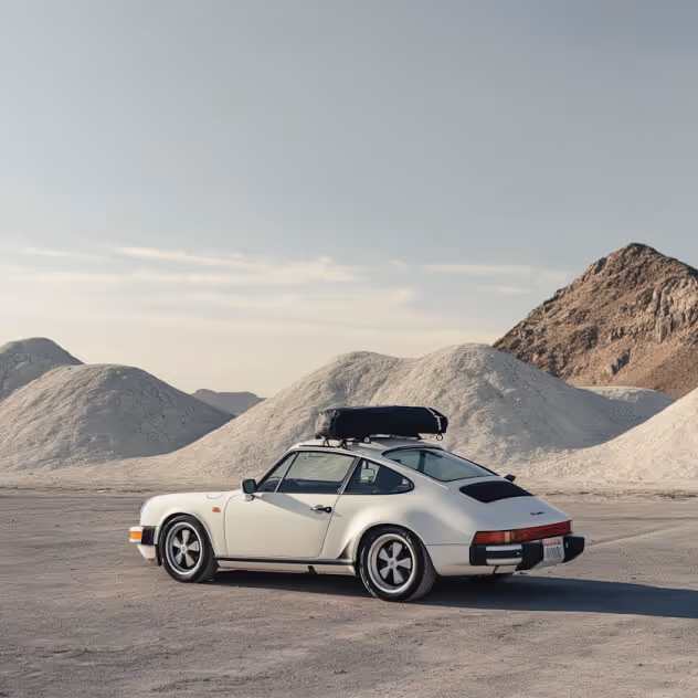 Silver sports car beside desert mountains