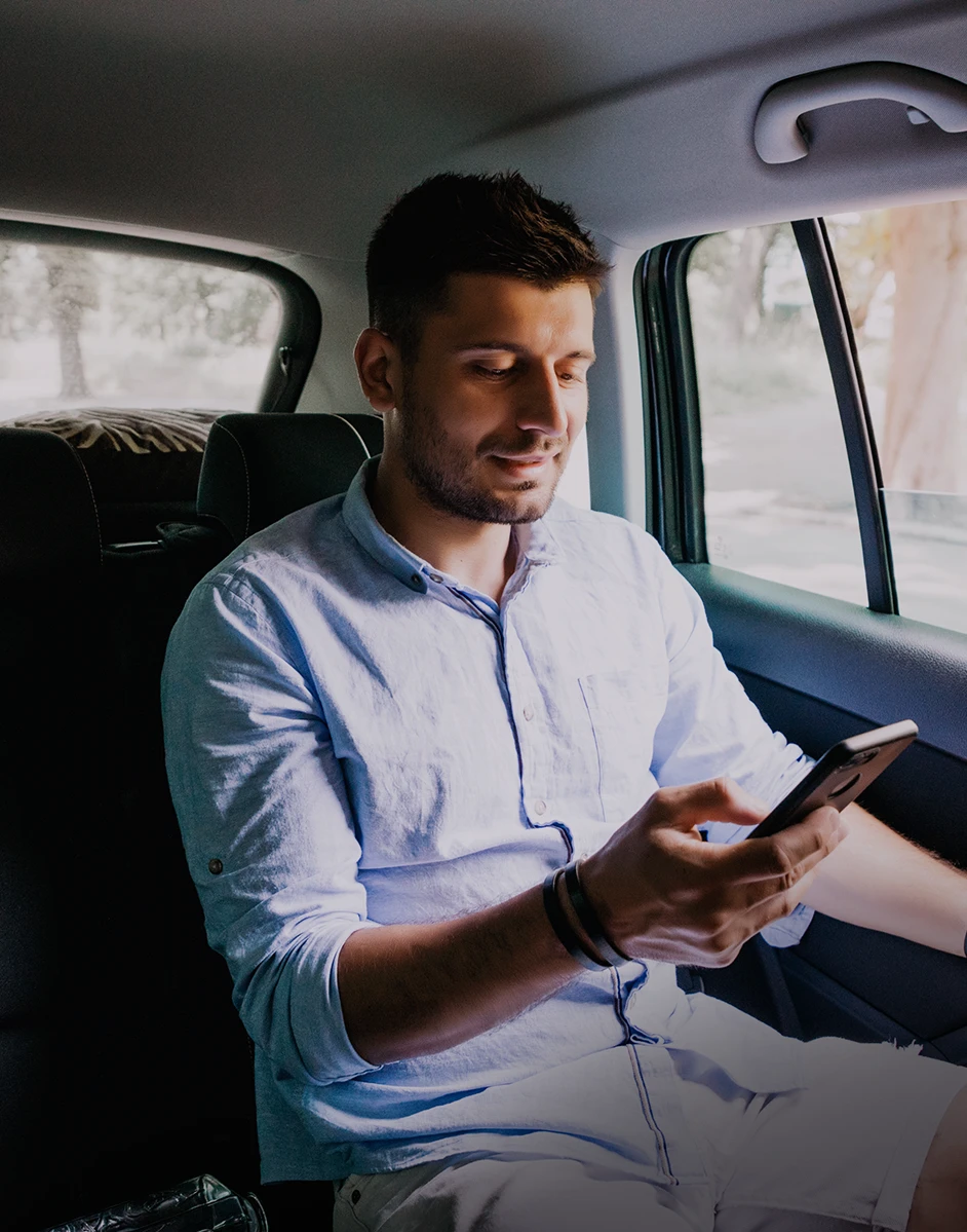 Passenger checking his phone during an Uber ride through Rego Park before a crash leads him to speak with a Rego Park Uber accident attorney