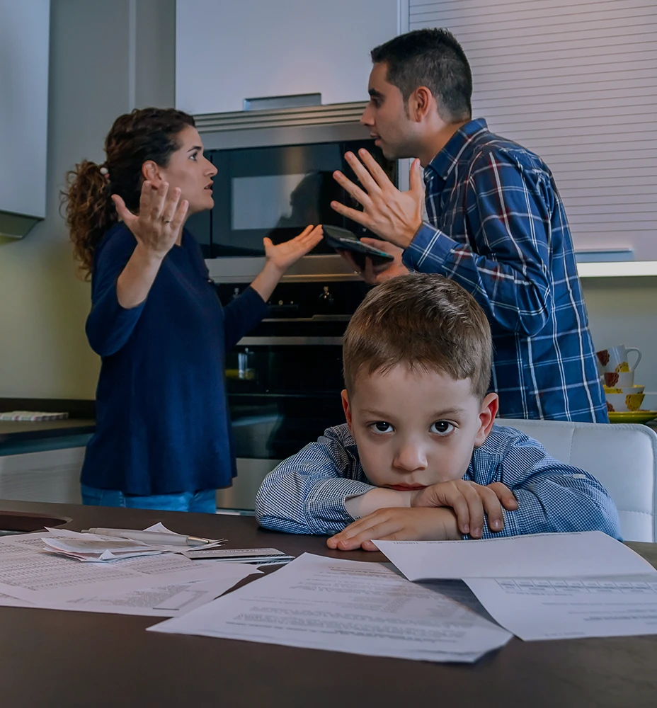 Child sitting in the foreground while parents argue behind him during a custody dispute, the kind of family conflict a Rego Park Child Custody Lawyer may help address