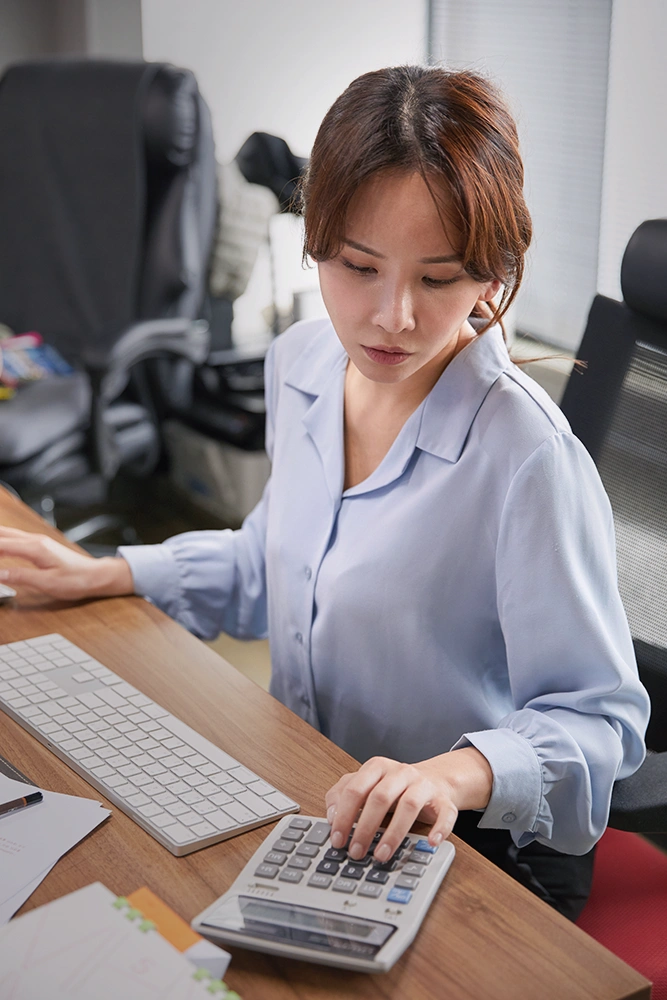 Woman reviewing income, expenses, and financial records while preparing to discuss divorce finances with a divorce lawyer in Rego Park