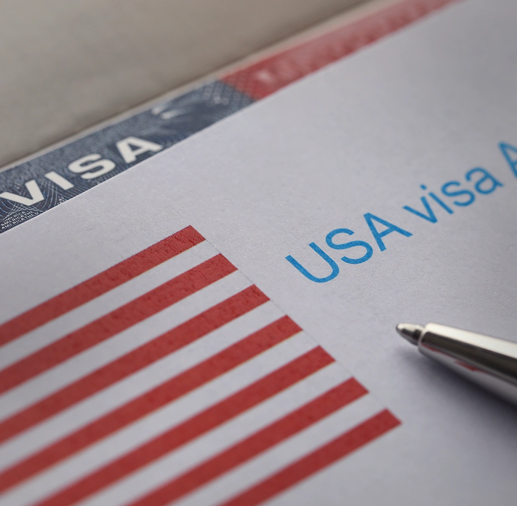 U.S. visa paperwork beside an American flag as an applicant works through an immigration barrier with an Immigration Waivers Attorney in Rego Park