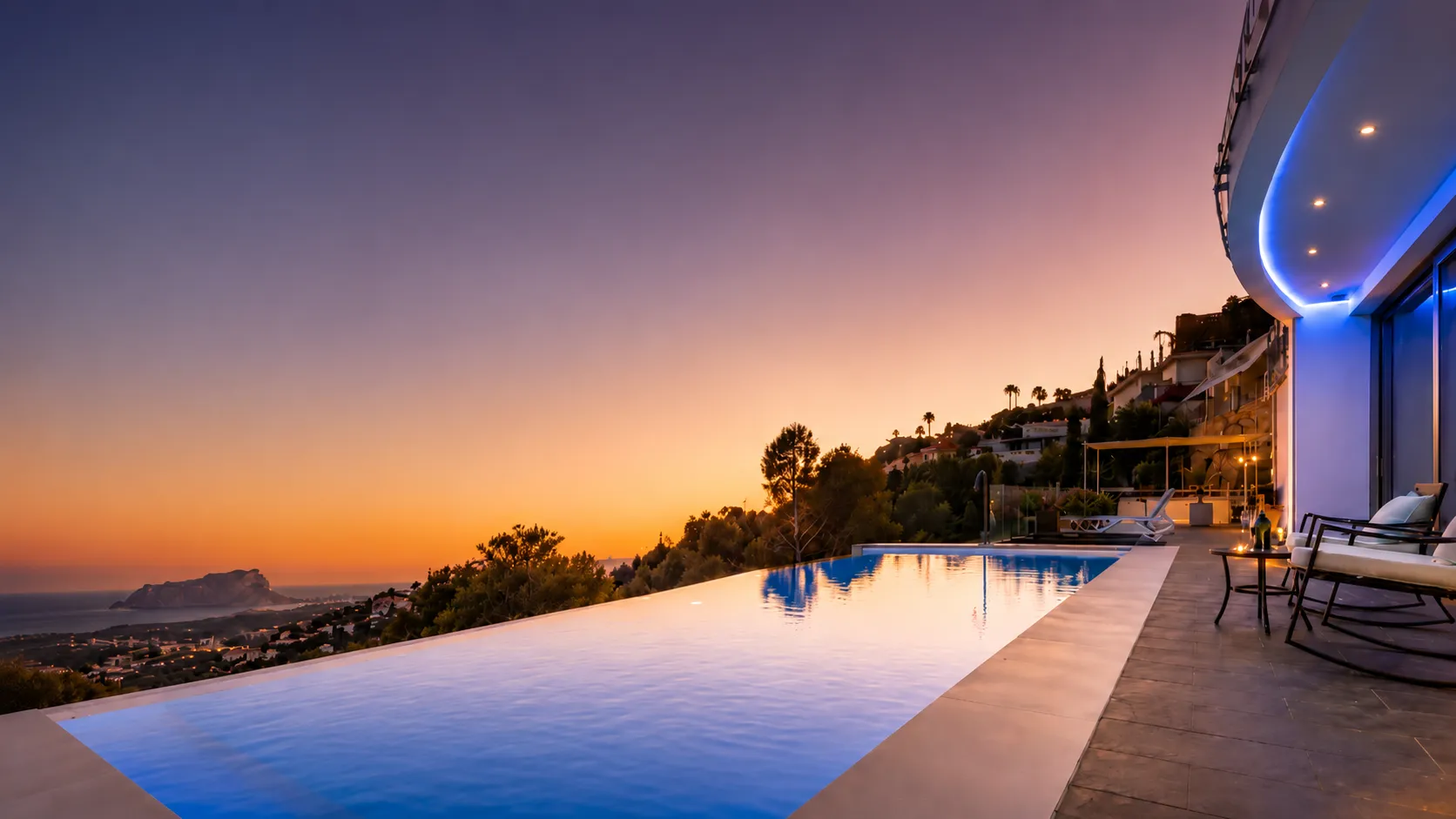 Piscina infinita de Moonlit BB al atardecer con vistas al mar.