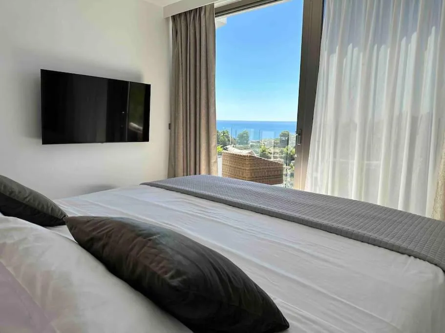 Habitación de Moonlit BB con cama, televisión y vistas al Mediterráneo.