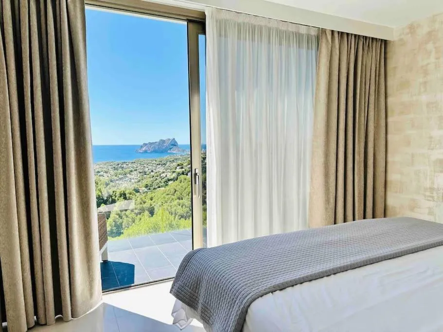 Habitación luminosa de Moonlit BB con grandes ventanales y vistas al mar.