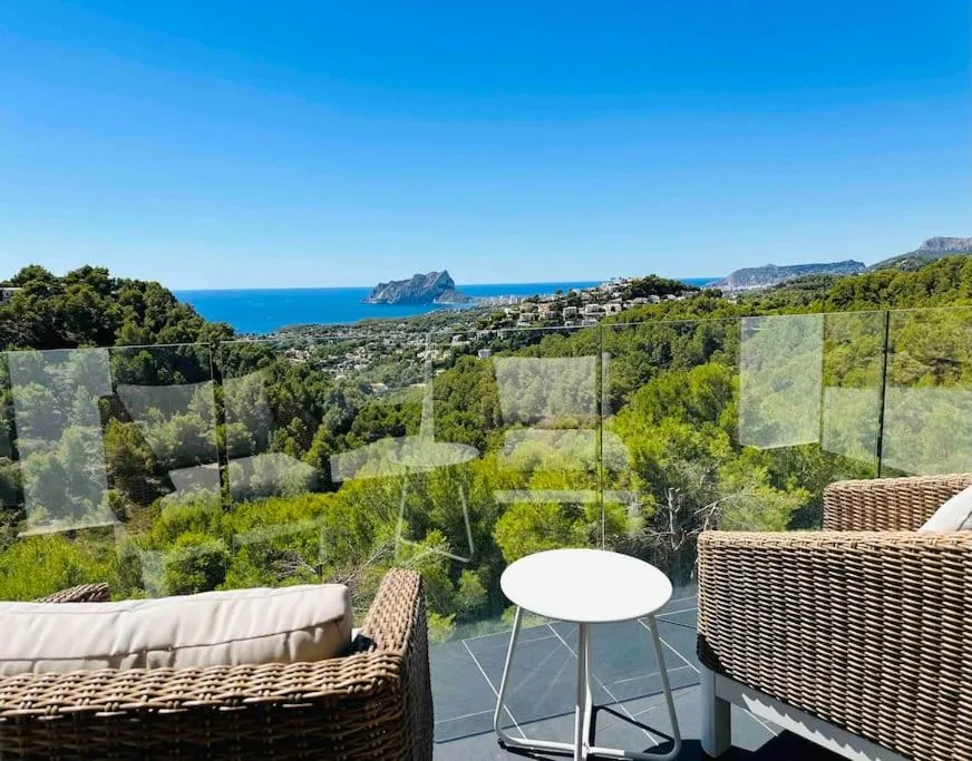 Terraza privada rodeada de vegetación con vistas al mar Mediterráneo.