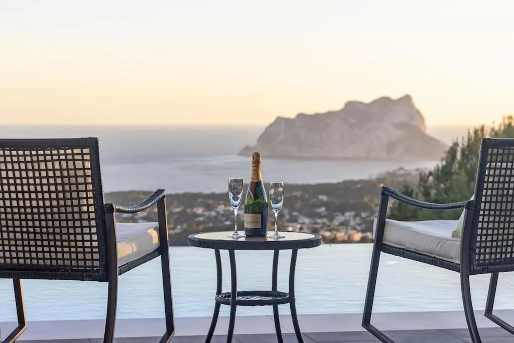 Terraza privada con mesa, asientos y vistas abiertas al Mediterráneo.