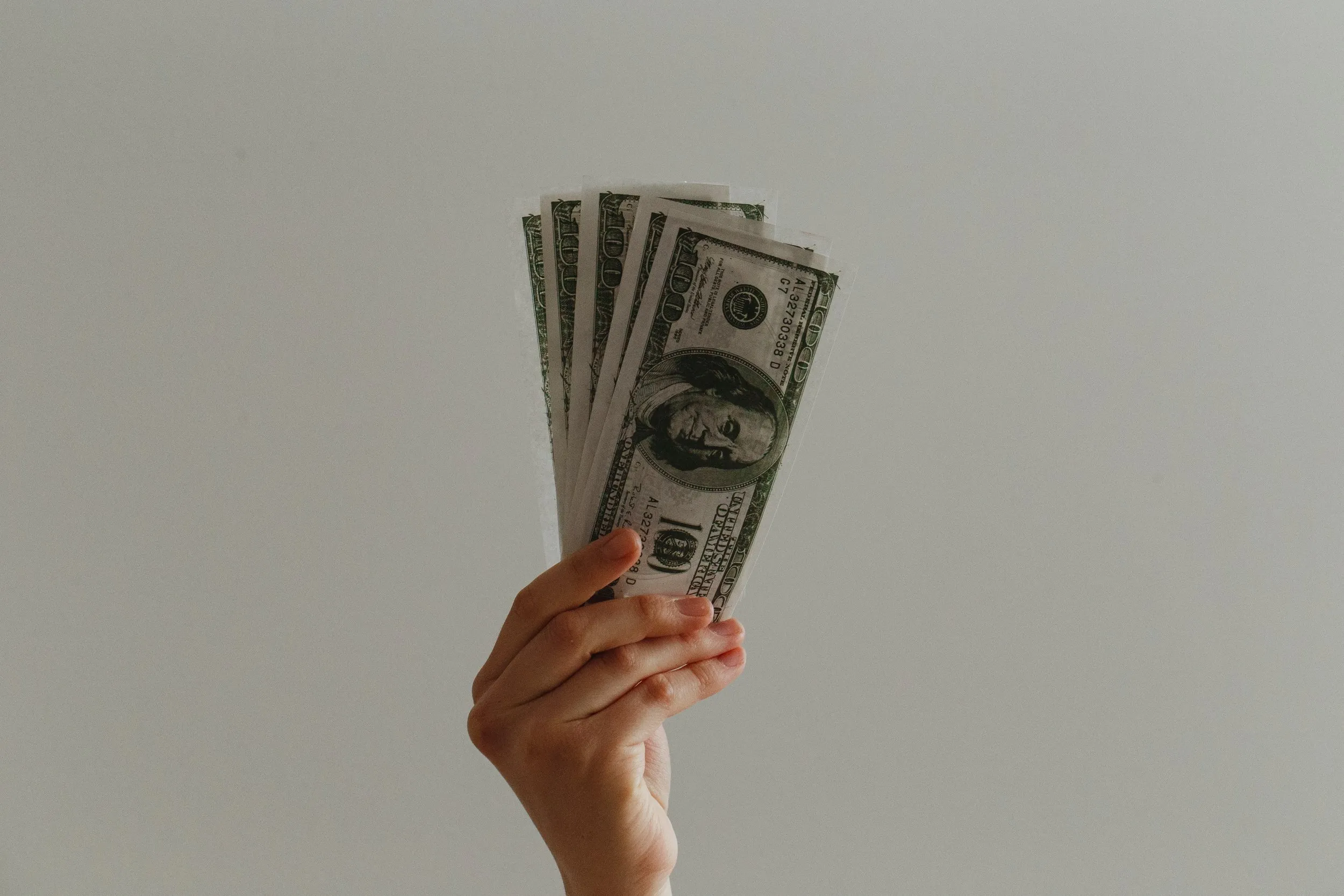 A hand holding up cash