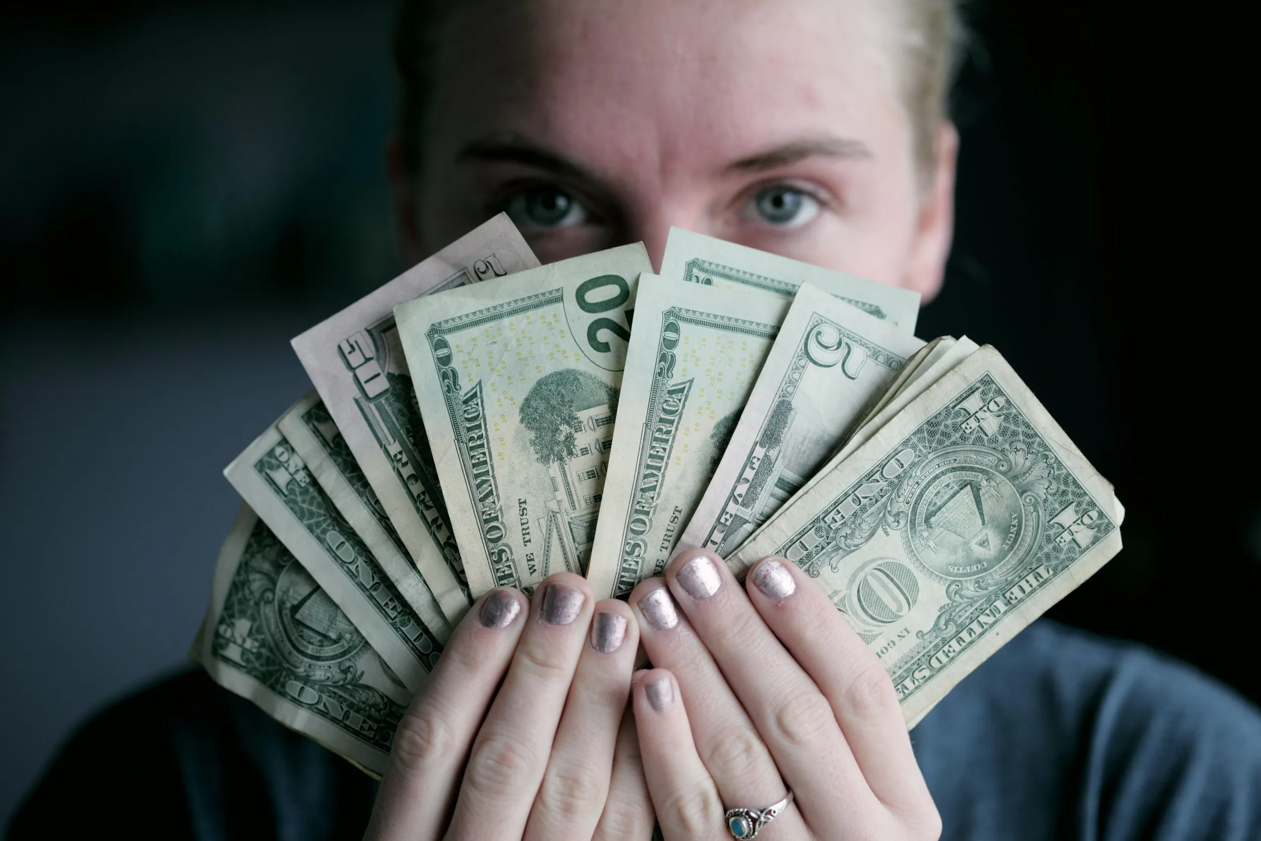 Someone holding cash and looking at the camera