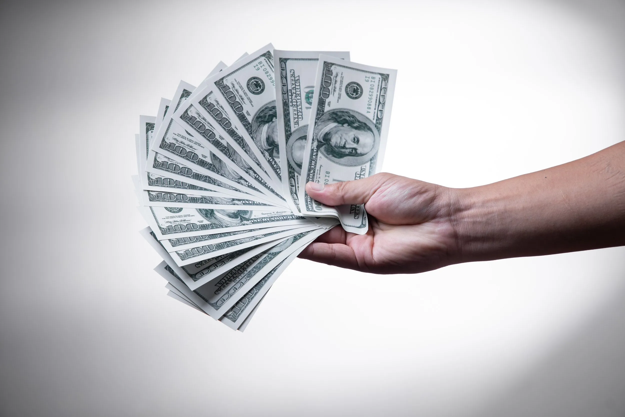 Hand holding wads of cash