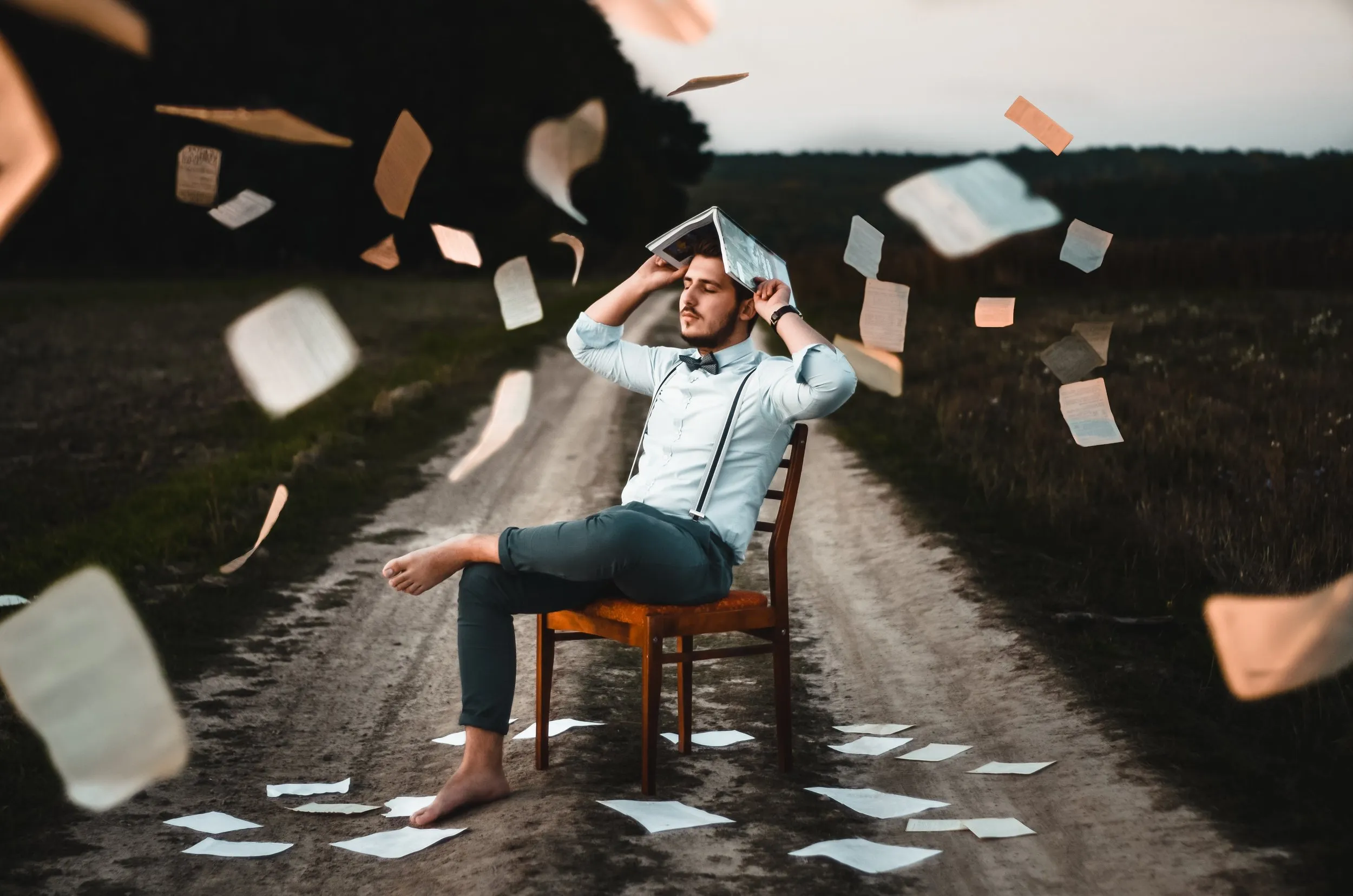 A person holding a book over their head looking frustrated