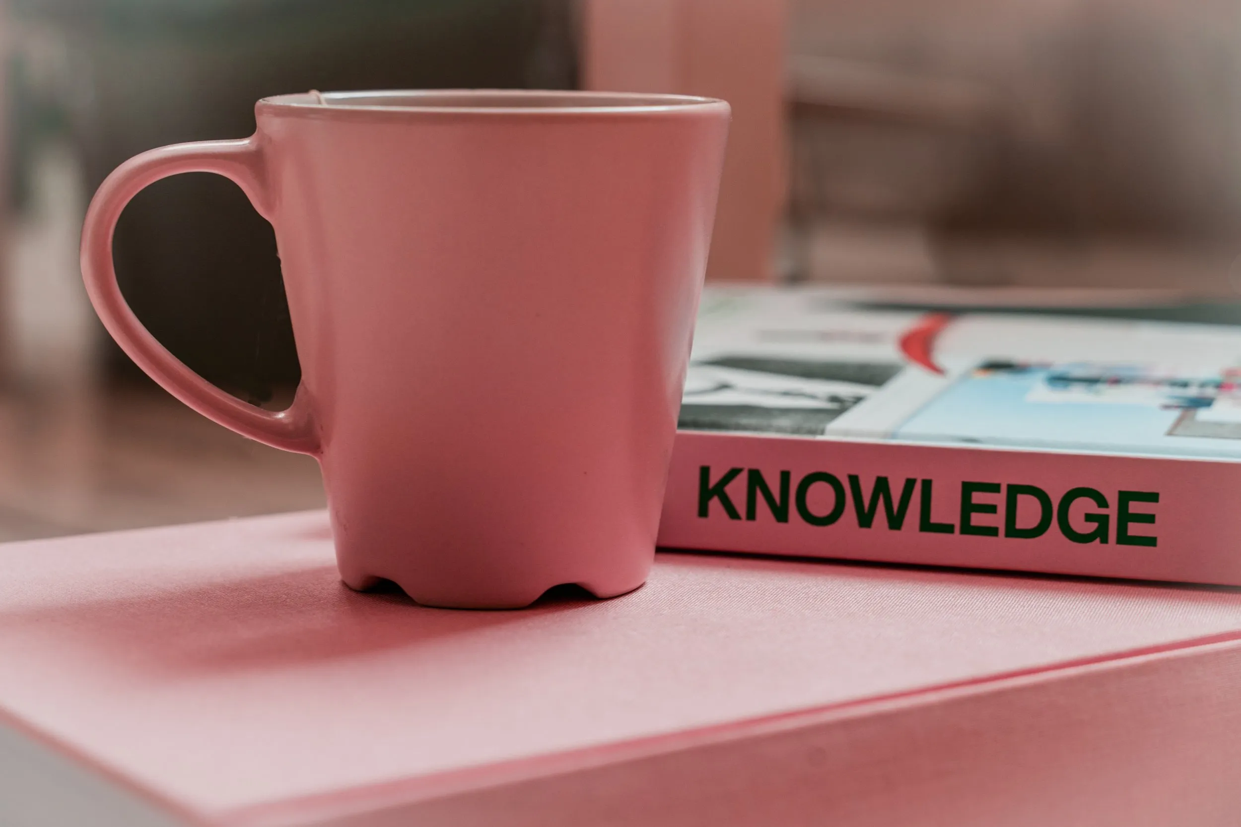 A pink mug next to the word "knowledge"