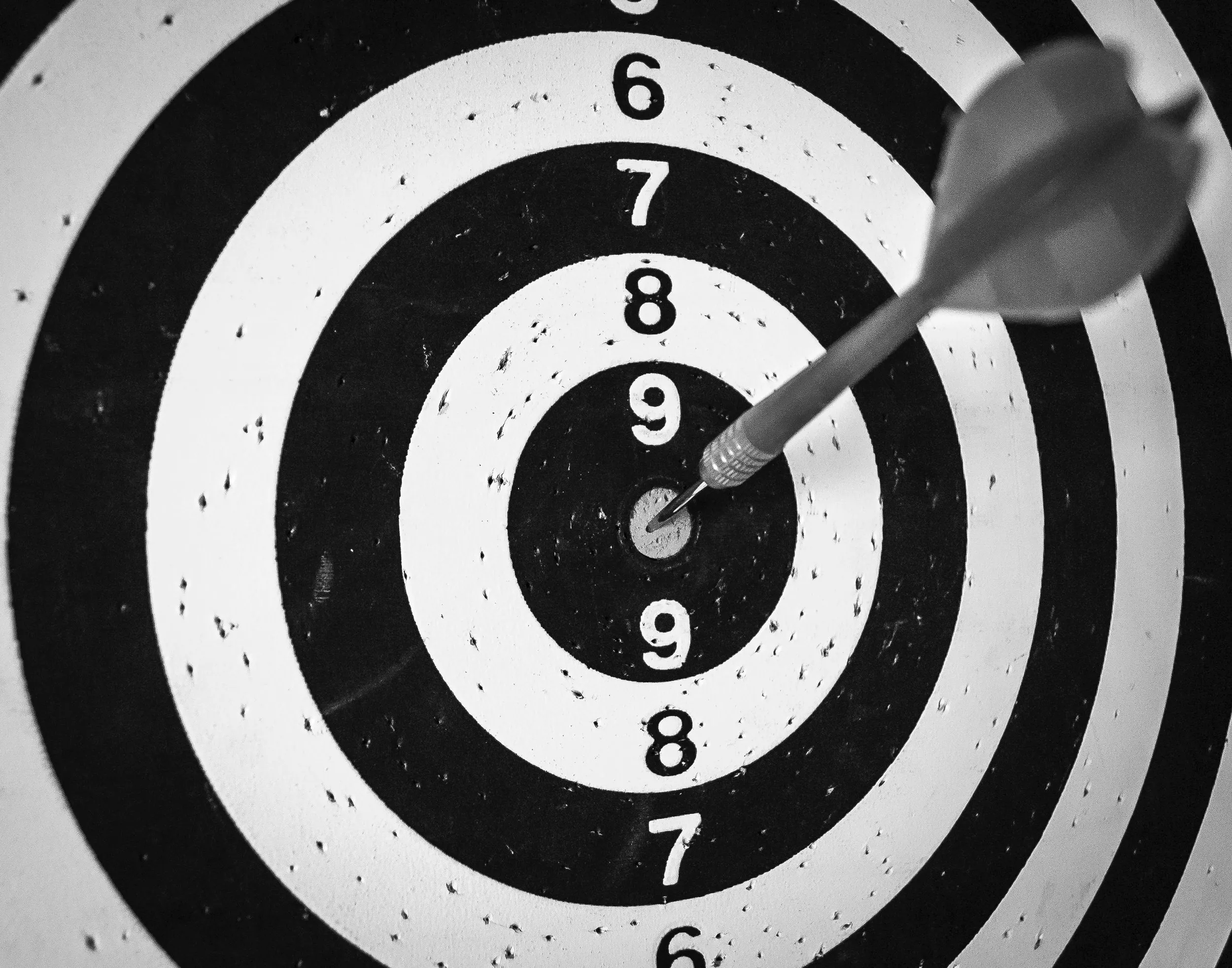 A dart board with an arrow in the center target