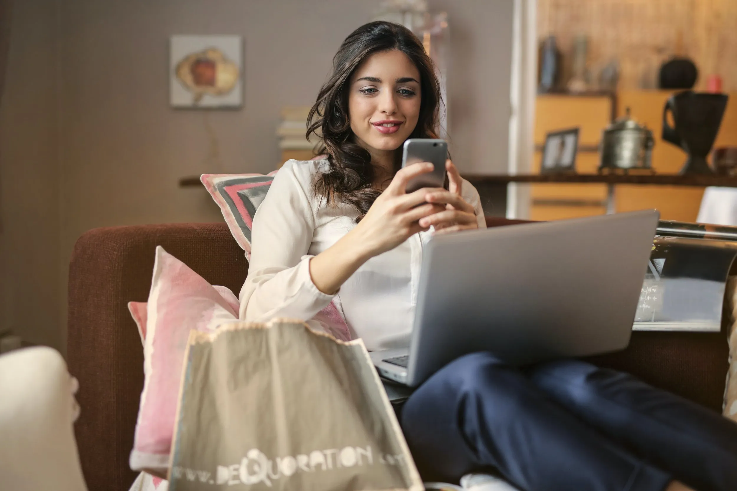 A woman looking happily at her phone screen