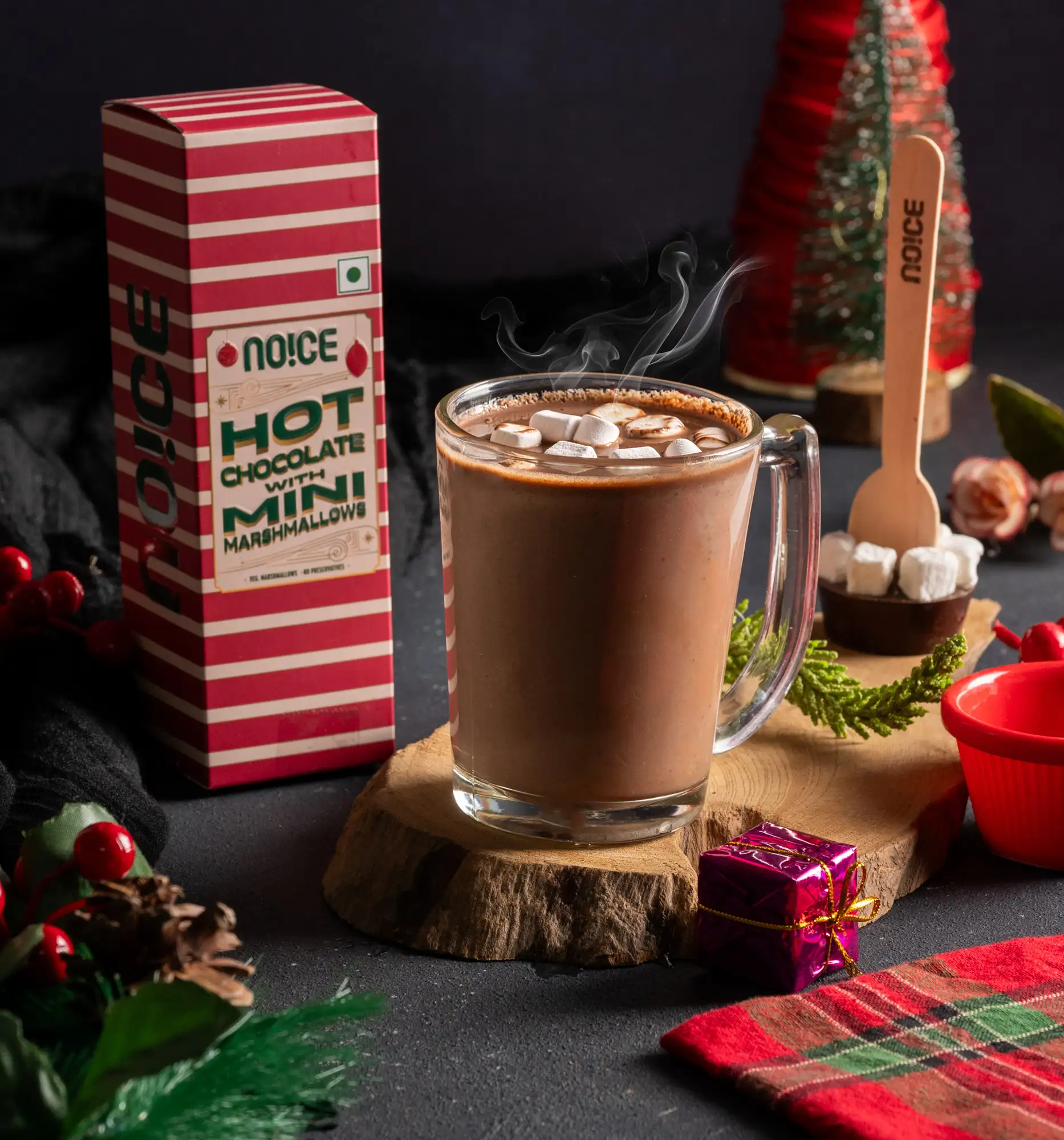 A mug of NOICE rich dark hot chocolate topped with fluffy white mini marshmallows and a smooth chocolatey swirl.
