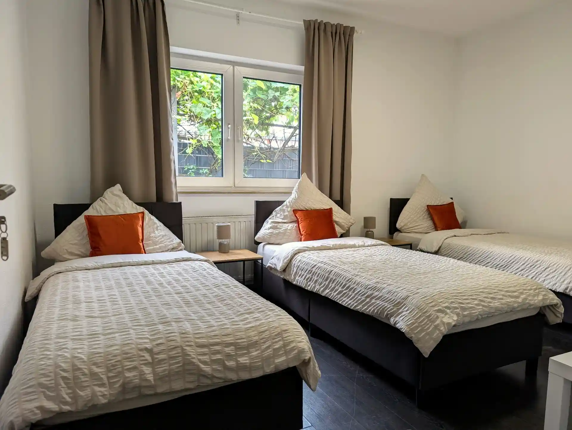 Dreibettzimmer im Erdgeschoss bei BASE stay Erlangen mit Blick ins Grüne