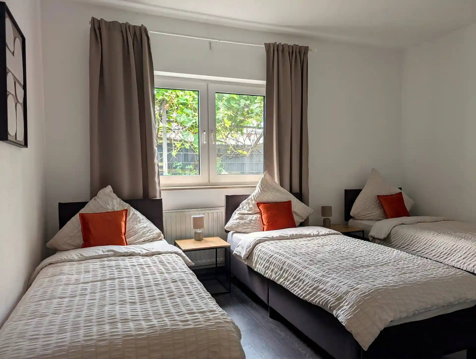 Dreibettzimmer bei BASE stay Erlangen mit Fenster und Blick ins Grüne