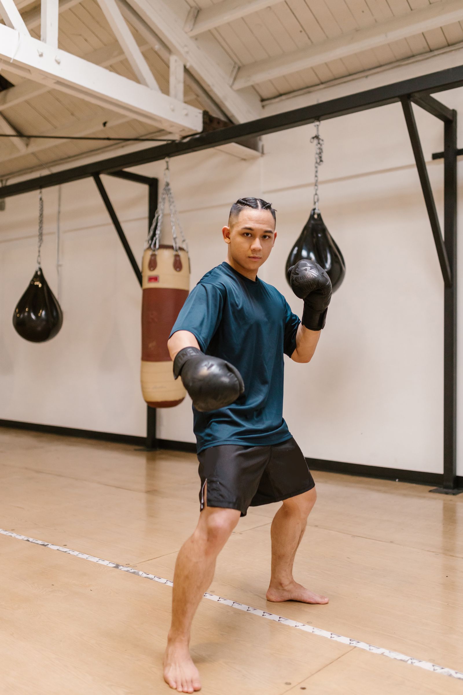 Boxeur à l'entraînement devant des sacs de cuir vintage