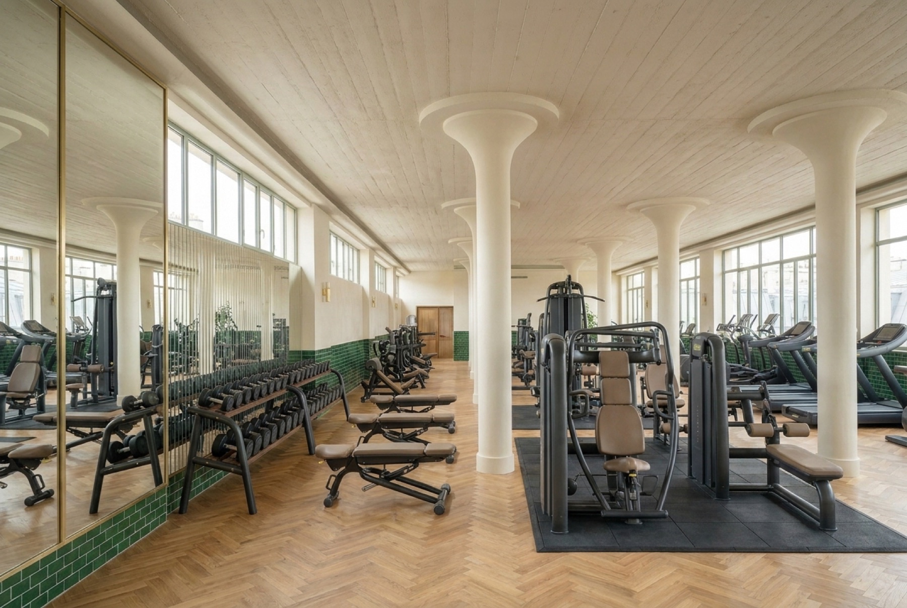 Le plateau : mur de miroirs derrière les haltères, machines guidées au centre, cardio le long des baies