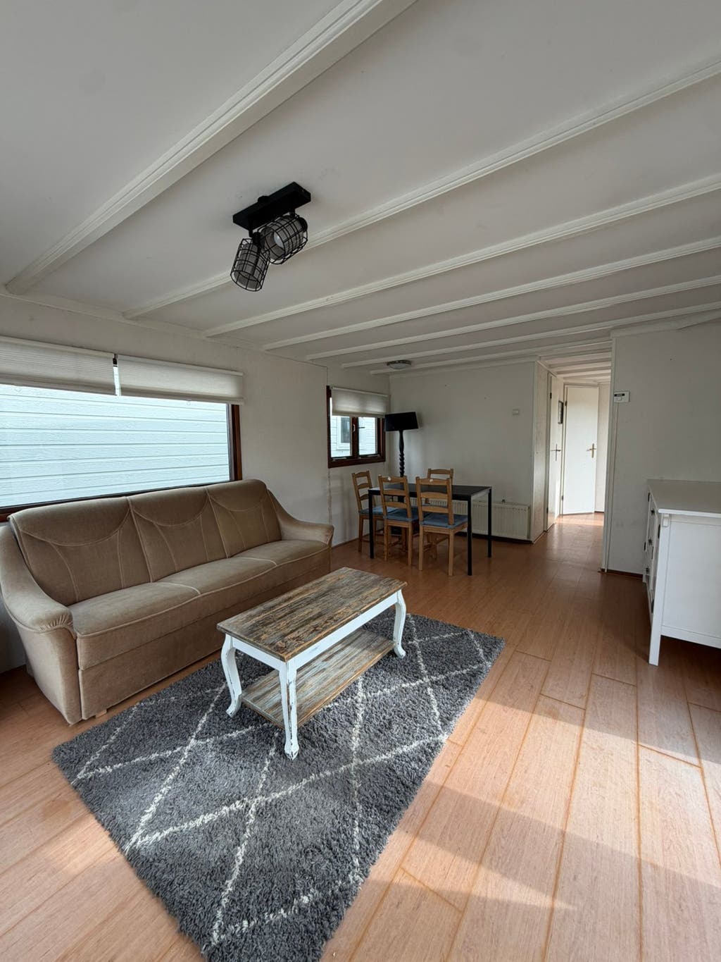 Woonkamer met zithoek en eethoek in het chalet 10,00 x 3,70 m.