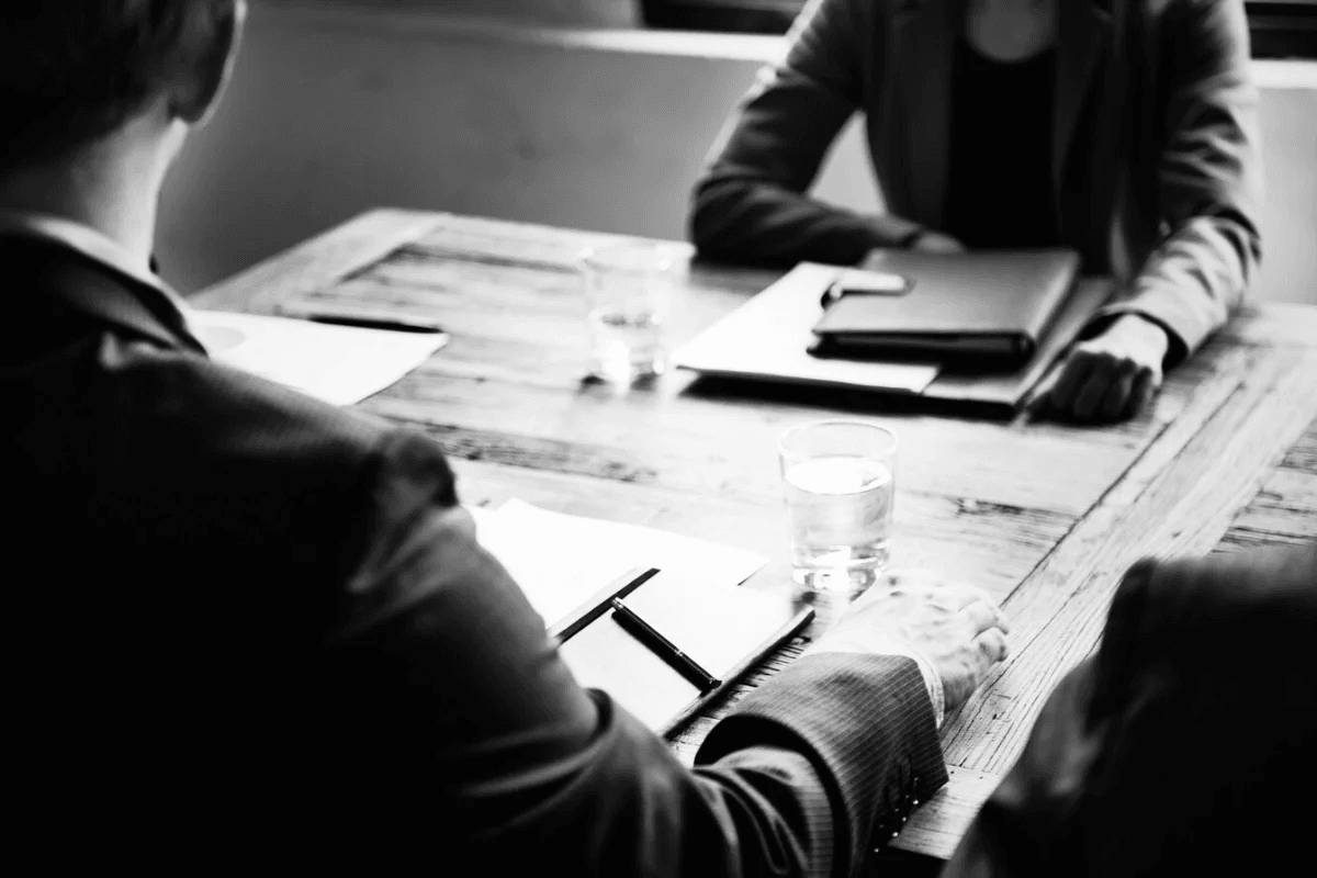 Monochrome photo of professionals at a meeting with documents.