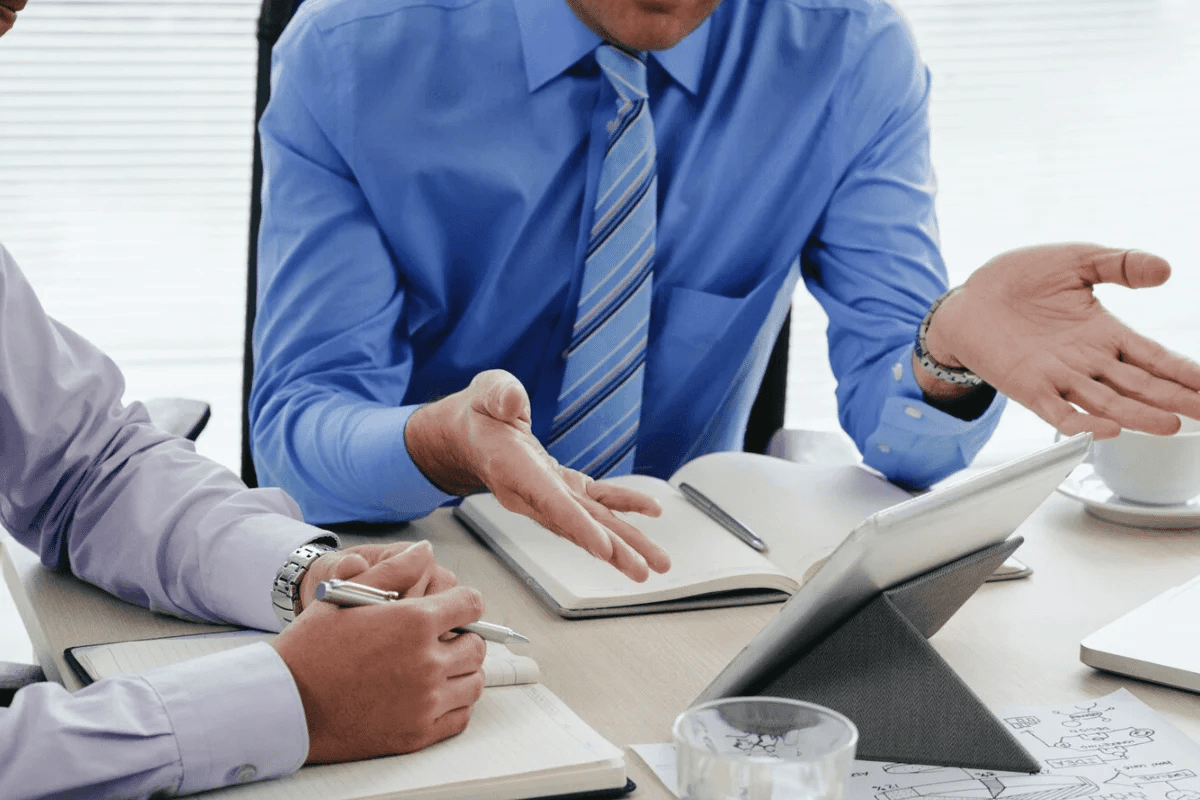 Corporate meeting with two professionals talking over documents.