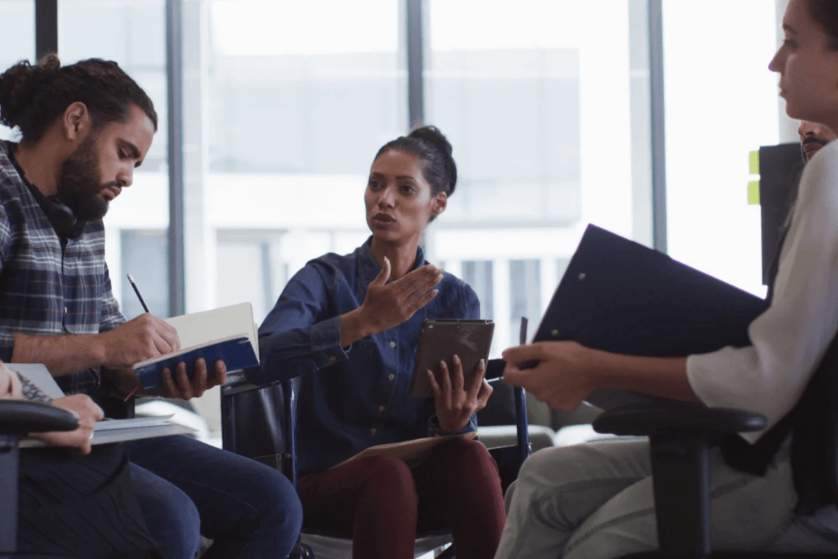 A diverse team of professionals engaged in a discussion in a modern office setting.