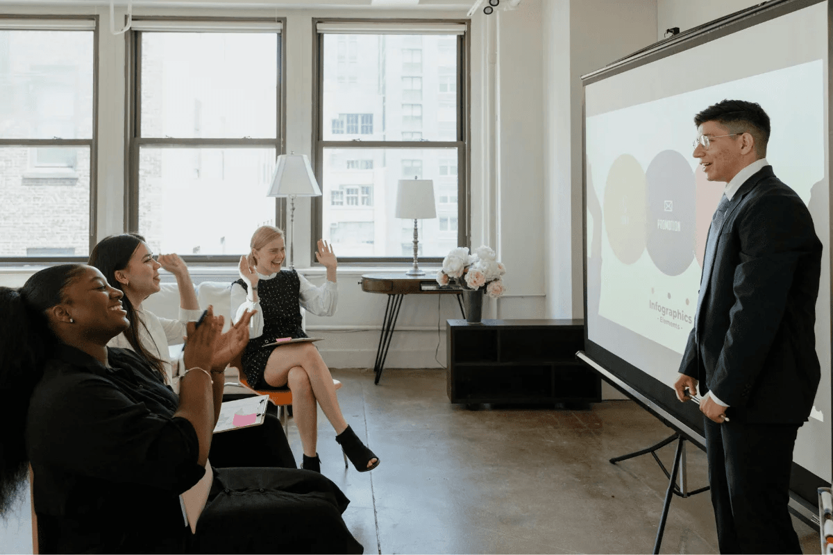 Business team applauding a presentation in a bright, modern meeting room.