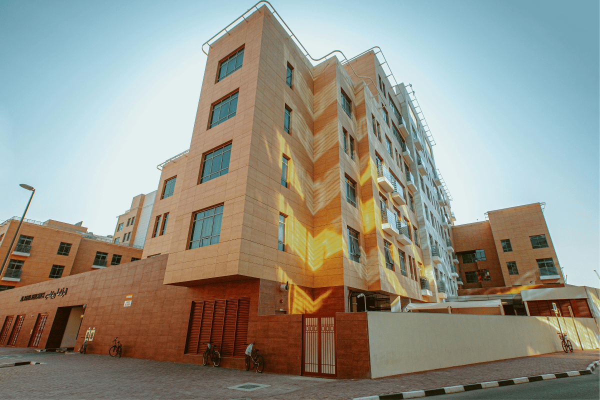 Modern apartment building bathed in warm sunlight, showcasing geometric architecture.