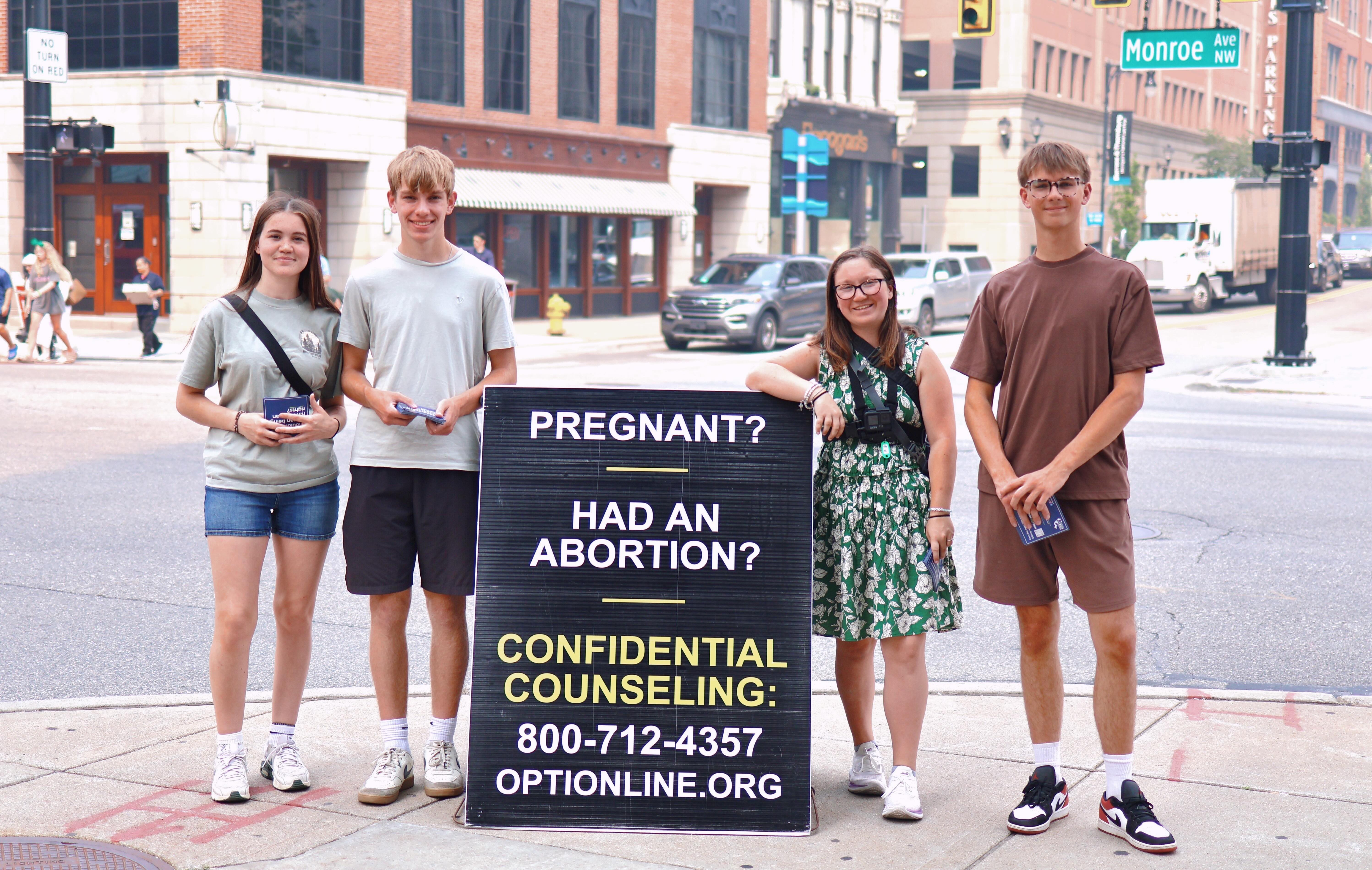 Protect Life Michigan students talking with a classmate on campus