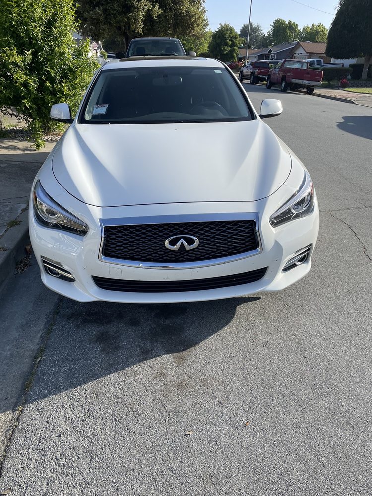 White Infiniti sedan detailed after collision repair