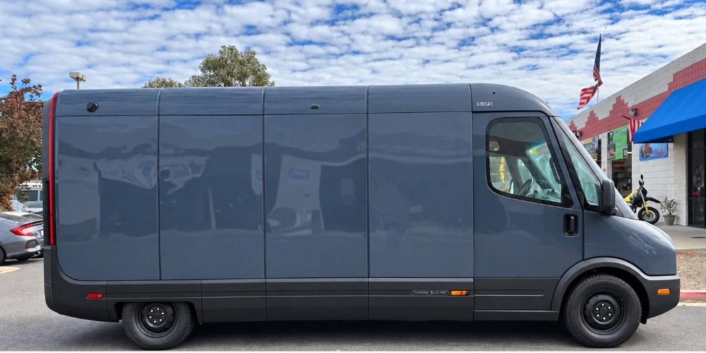 Same Amazon Rivian electric delivery van after collision repair at Spark Collision Center, new genuine Rivian side panels painted to match